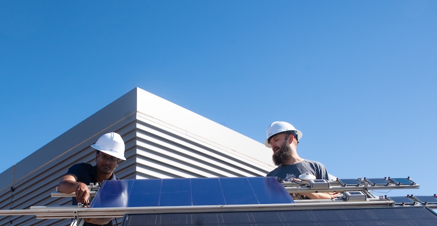 UC Merced graduate student ​Shariful Islam and Sean Dunfield of Tandem PV install a solar panel atop the SE2 building on campus.